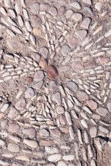 Tribal ornament of stones on road in Spain Fort. Background old texture walkway.