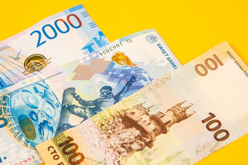 New design of money in Russia. A new bill of 100 rubles. Money of Russia on a background of yellow. New banknotes of a hundred rubles.