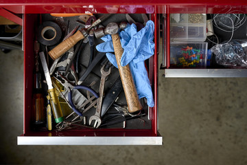 Fototapeta na wymiar overhead view of toolbox full of tools and work gloves inside a workshop. 