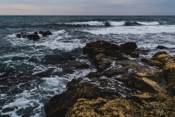 Storm on the sea in cloudy weather at sunset