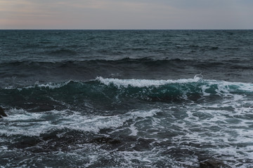 Storm on the sea in cloudy weather at sunset