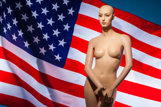 Sexual harassment in the United States. American flag. Mannequin naked woman against the American flag.