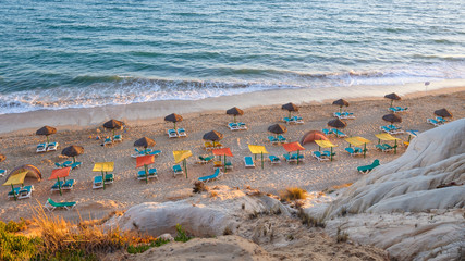 Fototapeta na wymiar Sunbeds and umbrellas on the Falesia Beach