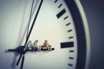 Group of workers having break with beer while sitting on clock hand