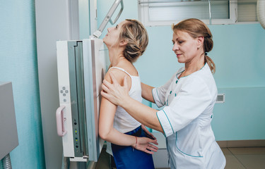 Radiologist and patient in a x-ray room. Classic ceiling-mounted x-ray system.