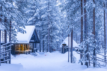 Travel Destinations Ideas. Illuminated Wooden House Located in Tranquil Picturesque Nordic Forest in Scandinavia At Christmas Time.