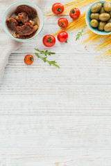 Ingredients for preparation pasta spaghetti - tomato, olive oil, spices, herbs, green olives, tomato sauce