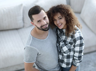 Fototapeta na wymiar young couple standing in new living room and looking at camera