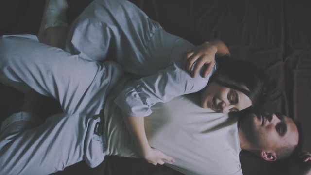love story. guy and girl in pajamas lie on the bed