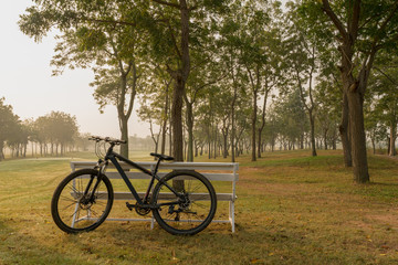 Fototapeta premium A bicycle with white bench having golf court as background