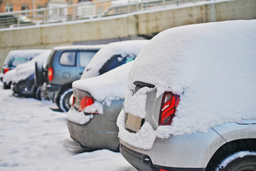 fresh white snow covered cars after snowfall. Winter urban scene.