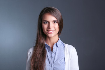 Portrait of a businesswoman , against dark background. Woman smiling. Portrait of a woman