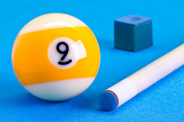 Billiard pool game nine ball with chalk and cue on billiard table