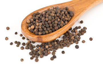 Heap of raw, natural, unprocessed black pepper peppercorns in spoon