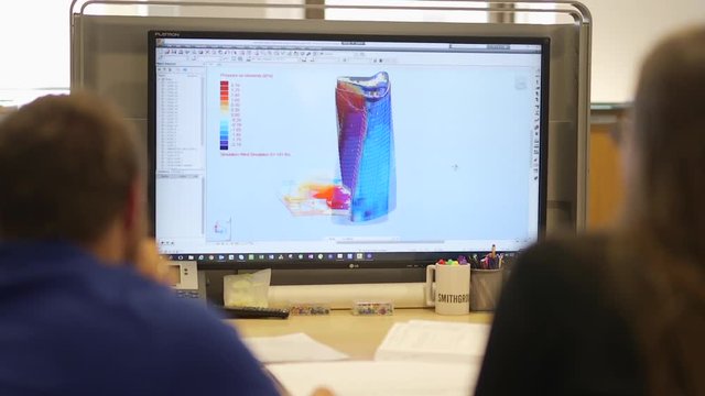 Two engineers collaborate over a digital 3D design of a concrete structure