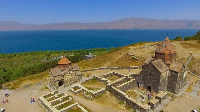 Quadcopter flying over old Sevanavank monastery complex, tourism in Armenia