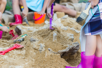 Children are learning dinosaur remains, Excavating dinosaur fossils simulation in the park. © piyaphunjun