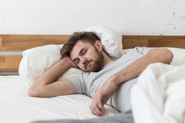 Fototapeta na wymiar Caucasian young man sleep on bed in the morning