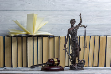 Legal Law concept - Open law book with a wooden judges gavel on table in a courtroom or law...