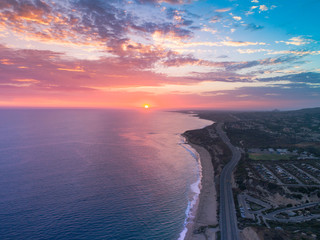 Aerial view over Crystal Cove in Newport Beach at sunset overlooking the beautiful Pacific Coast Highway and ocean.