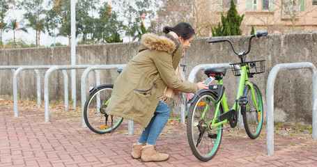 Fototapeta premium Woman using share bike in the city