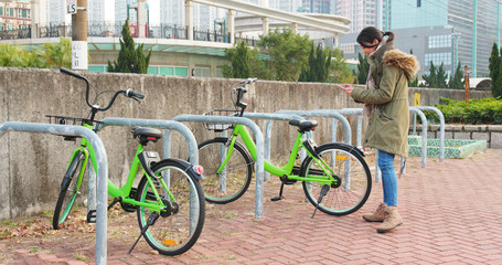 Woman using share bike in city