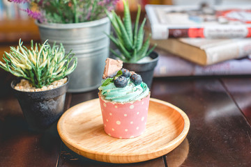 Cupcake strawbery with cream and chocolate  stick on the wood dish, grain, Blueberry, Selective focus