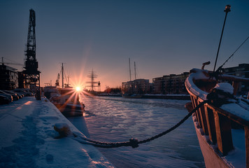 Beautiful scenic view of boats anchored on Aura river in Telakkaranta during winter sunset with...