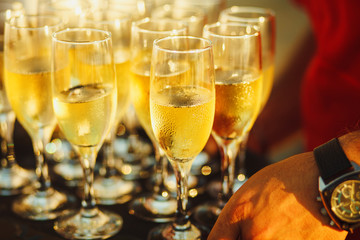 cold champagne on the tray. Sparkling wine poured by the glass.