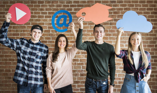 Friends holding up social media and technology concept icons - Powered by Adobe