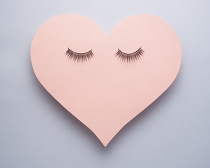 Wake up / Creative concept photo of heart with eye lashes on grey background.