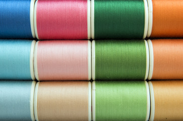 Colorful sewing threads background closeup
