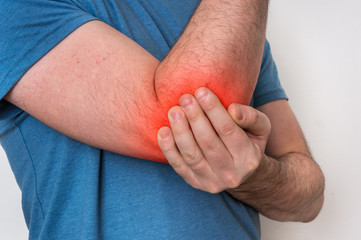 Man with elbow pain is holding his aching arm