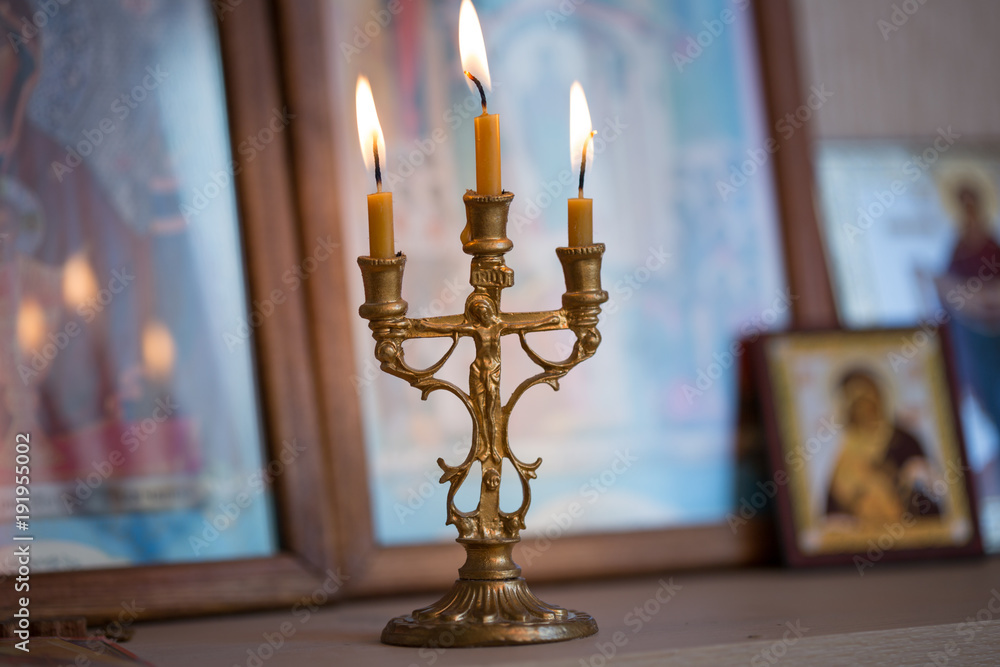 Poster candle against the background of orthodox icons