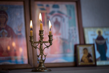 candle against the background of orthodox icons