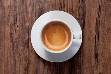 Foto op Plexiglas top view a cup of espresso coffee on wooden table background © joesayhello