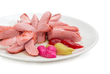 Fried vienna sausages with various condiments on white dish