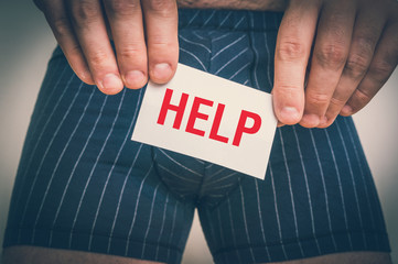 Man with incontinence problem holding paper with HELP