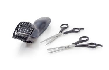 Two pairs of different hairdressers scissors and electric hair clipper