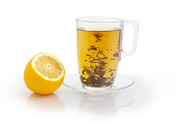 Glass cup of black tea during brewing and lemon