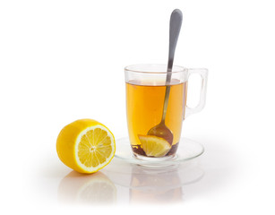 Glass cup of black tea with flowers additive and lemon