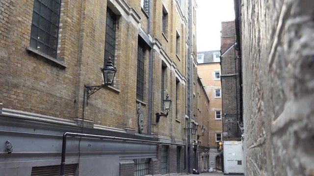Lamps on the wall of a building in a narrow street. London.