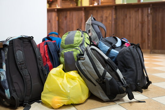 Tourist backpacks stand on the floor indoors.