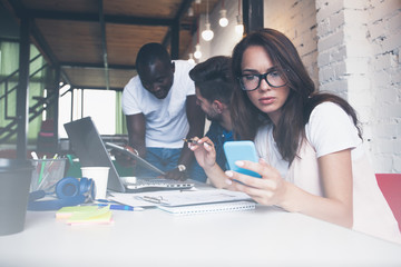 Teamwork concept, brainstorming. Businessman crew working with new startup project in modern loft. Woman holding smartphone hands.