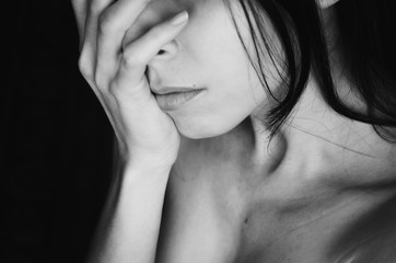 Young woman cover her face with hand black white