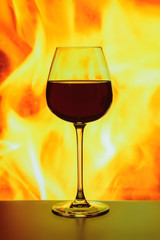 A glass of red wine on the background of the flame
