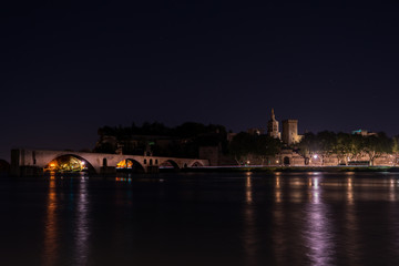 Fototapeta na wymiar Night view of St. Benezet Bridge with Palace of Pope in Avignon , France Rhone river in foreground