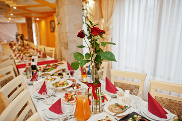 Wedding table decorated with red roses in the restaurant.