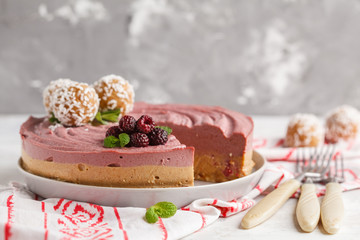 Pink berry caramel raw vegan cheesecake with coconut sweet raw balls. Healthy vegan food concept.
