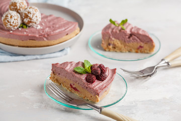 Pink raspberry raw vegan cheesecake with coconut sweet raw balls. Healthy vegan food concept.
